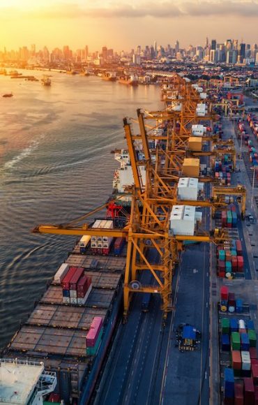 Container ship in import export and business logistic. Trade Port. Shipping, cargo to harbor and Cargo plane with working crane bridge in shipyard at sunrise, logistic import export and transport indu